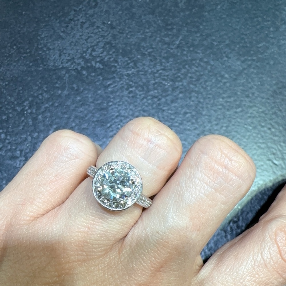 It is a 14k ring with a 1.50 ct diamond and many smaller ones around the ring,